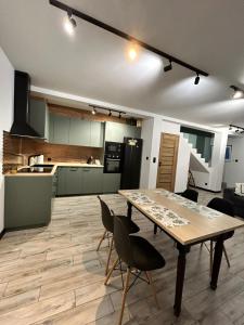 Una gran cocina con una mesa y sillas de madera. en Lipowa Nest, en Lipowa