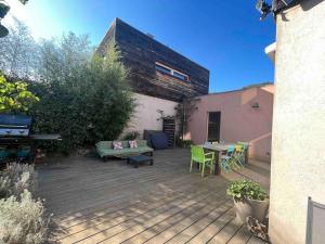a backyard with a wooden deck with a table and chairs at Maison Lili 2 chambres in Conca