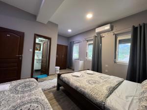 GusinjeHotel Mountain View Inn的有两张床和一扇窗户的卧室