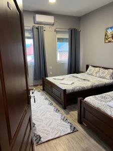 a bedroom with two beds and a door with a mirror at Hotel Mountain View Inn in Gusinje