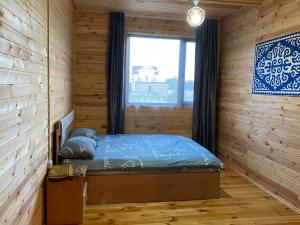 a bedroom with a bed in a wooden room at Beach HOUSE in Cholpon-Ata