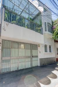 een gebouw met twee garagedeuren en een balkon bij The Condesa House in Mexico-Stad
