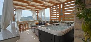 a hot tub on the balcony of a house at Holiday Home Peran in Grebaštica