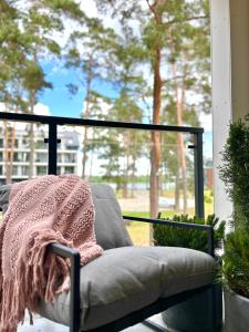 a blanket sitting on a chair on a porch at Apartamenty Bryza nad jeziorem in Augustów