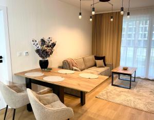 a living room with a table and a couch at Apartamenty Bryza nad jeziorem in Augustów