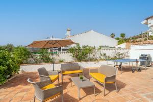a patio with chairs and a table and an umbrella at Rosa in El Cerro
