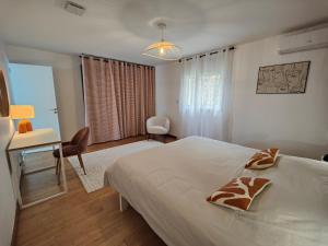 a bedroom with a bed and a desk and a chair at Home Ocean 360 piscine chauffée et SPA in Saint-Leu +43 photos
