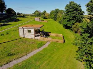 a smallshed on a grassy field with a pathway at Anniston Mill Cabin 1 in Arbroath