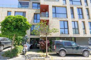 un edificio con due auto parcheggiate di fronte di Sunny flat with pool a Varna