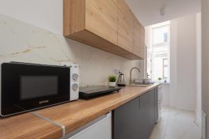 a kitchen with a microwave on a wooden counter at Centrum2a Łódź Próchnika 21 in Łódź