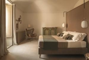 a bedroom with a bed and a chair at Dimora Santagatha in Noto