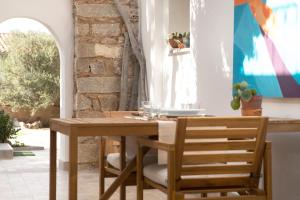 a dining room with a wooden table and chairs at Villa Silvia Apartments in La Maddalena +18 photos