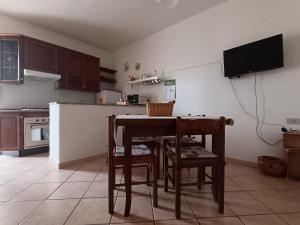 a kitchen with a table and chairs in a kitchen at Piccione Marittimo Appartamento Vicinanze Mare in Livorno