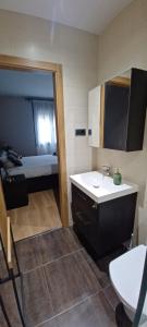 a bathroom with a sink and a mirror and a bed at Piso a pie de playa con terraza exclusiva in Moaña +43 photos