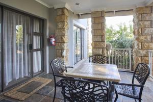 a patio with a table and chairs on a porch at Villa Mohau 178 in Clarens