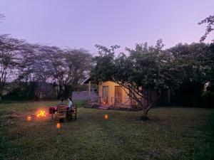 two people sitting at a table in a yard with fires at Nguse River Camp in Kikube