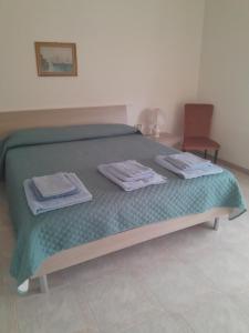 a bedroom with a bed with towels on it at "SHARDANA" CASA VACANZe in Gonnesa