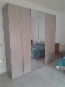 a wardrobe with glass doors in a room with a bed at "SHARDANA" CASA VACANZe in Gonnesa +13 photos