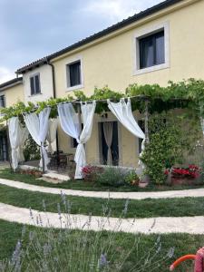 a house with white curtains in a yard at Hisa STERNA - WELL HOUSE in Zgornje Škofije
