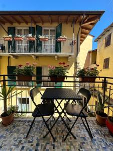 una mesa y sillas en un balcón con un edificio en Apartment Jessy, en Baveno