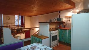 a small kitchen with a stove and a refrigerator at Studio Loft in Belgentier