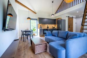 a living room with a blue couch and a table at Wilcza Stodoła in Wilcze