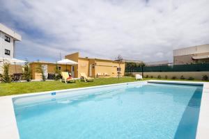 a large swimming pool in front of a building at Pontes Guest House in Arcozelo