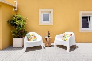 a patio with two chairs and a bottle of wine at Pontes Guest House in Arcozelo