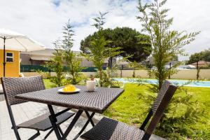a table with a plate of oranges on a patio at Pontes Guest House in Arcozelo