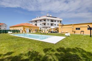 a large building with a swimming pool in a yard at Pontes Guest House in Arcozelo