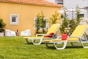 a group of chairs sitting on the grass at Pontes Guest House in Arcozelo