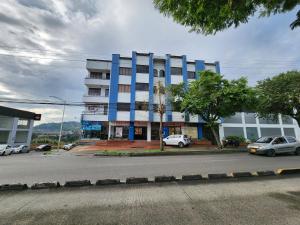 a blue building with cars parked in front of it at Bello y amplio apartamento cerca al aeropuerto in Pereira