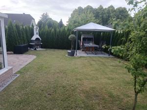 a backyard with a gazebo and a grill at Ferienwohnung Ankerplatz Züssow in Züssow