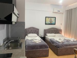 a hotel room with two beds and a sink at Studio Apartments Rizarjo in Ksamil