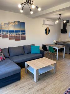 a living room with a blue couch and a table at Antracytowy Zakątek in Łeba