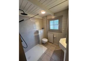 a bathroom with a shower and a toilet and a sink at Chaletparc Krabbenkreek - Chalet 266 in Sint Annaland +23 photos
