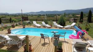 密古雷休治Casa Genesini的带滑梯、椅子和桌子的游泳池