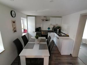 a kitchen with a white table and chairs in a room at Ferienwohnung in Mittelsaida in Großhartmannsdorf