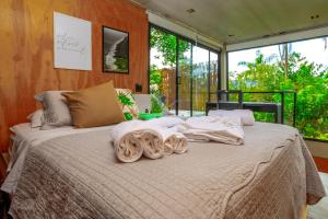 a bedroom with a large bed with towels on it at Casa Natu Ilhabela Portinho in Ilhabela