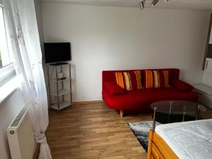 a living room with a red couch and a television at Unterkunft LUSCHIN in Spielberg