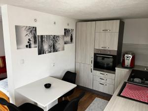 a small kitchen with a white table and a table and chairs at Unterkunft LUSCHIN in Spielberg