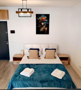 a bedroom with a large bed with two towels on it at Studio President 52 in Craiova
