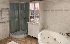 a bathroom with a shower and a bath tub at 2 Bedroom Nice Home In Ystad in Ystad +7 photos
