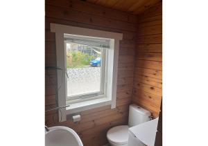 a bathroom with a toilet and a window at Chaletparc Krabbenkreek Zeeland - Chalet 96 in Sint Annaland +17 photos