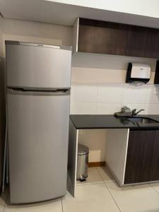 a small kitchen with a refrigerator and a sink at Vista al Río Paraguay, Costanera Asu in Asuncion