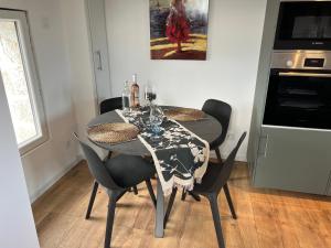 a dining room with a table with chairs and a painting at LES RONCES in Reterre