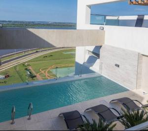 a swimming pool in front of a building with chairs at Vista al Río Paraguay, Costanera Asu in Asuncion