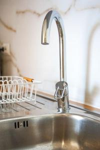 - un évier de cuisine avec un robinet et un porte-vaisselle dans l'établissement Renovated Traditional House w 3BR & Outdoor Space, à Funchal