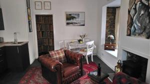 a living room with a leather chair and a table at The Studio in Orkney