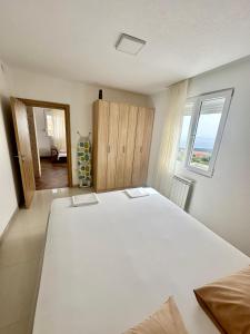 a large white bed in a room with a window at Montenegrina Apartment in Budva